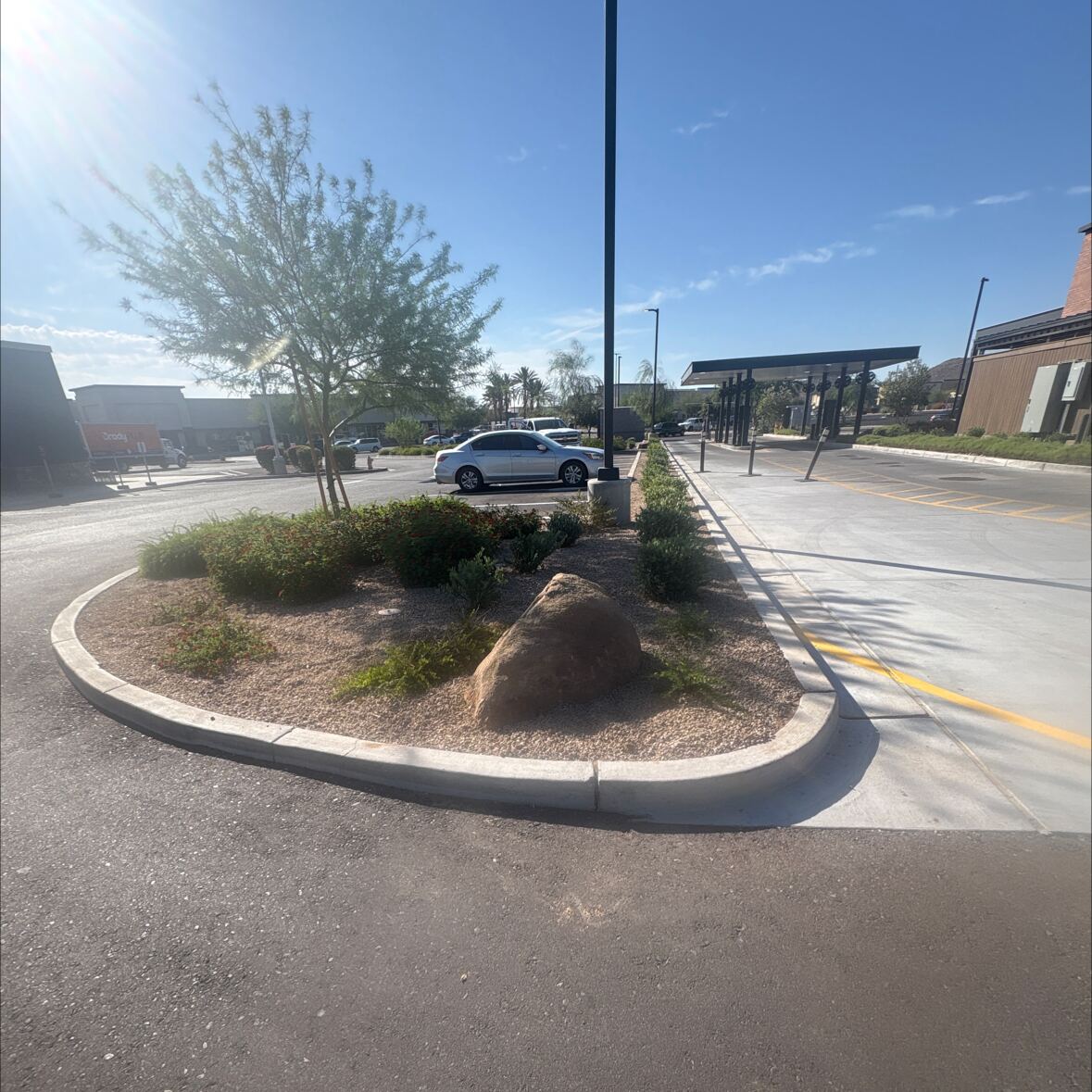 Finished commercial landscaping with boulders, desert plants and clean asphalt at a Phoenix-area retail property