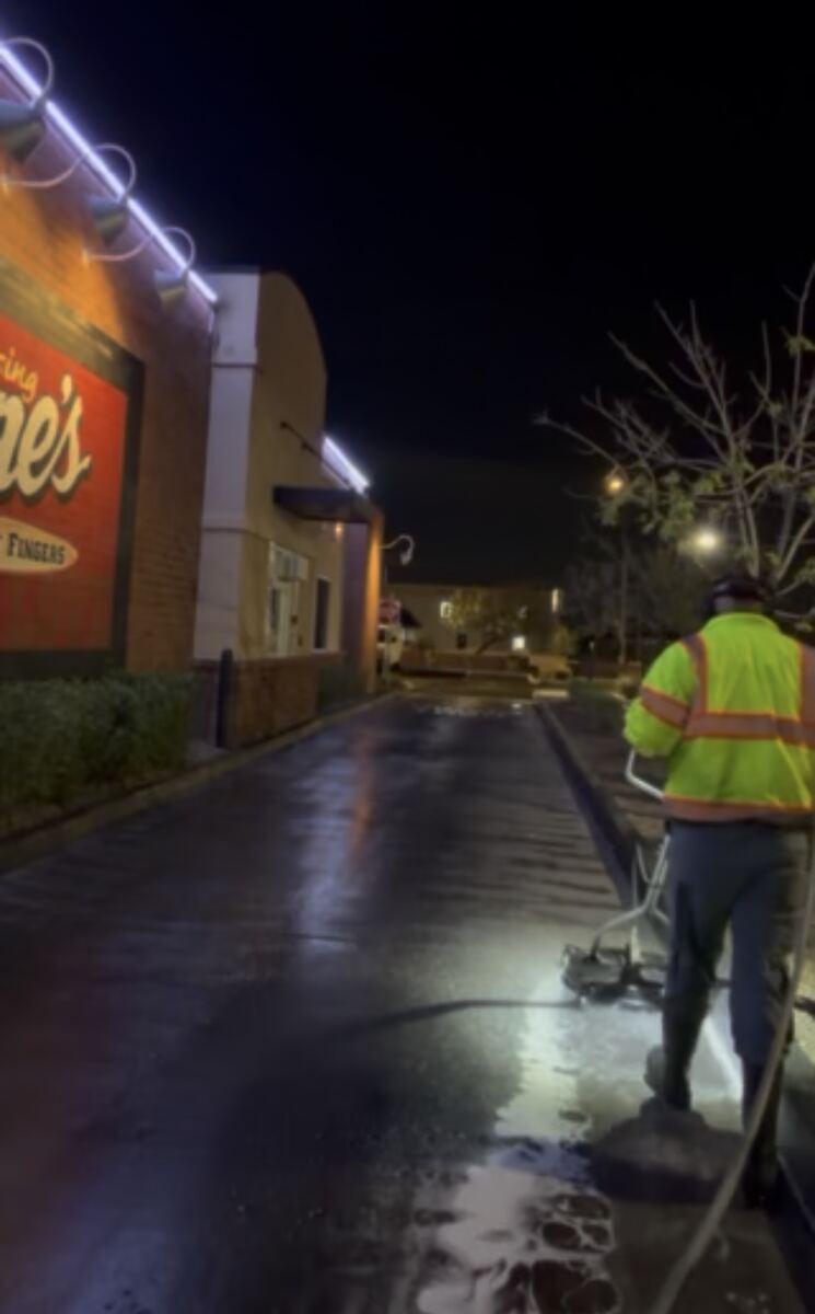 Night-time hot water power washing of a commercial storefront sidewalk